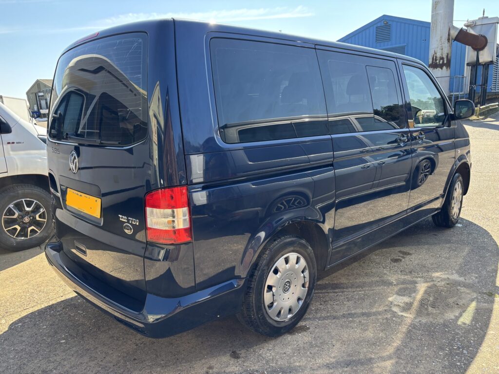 Dark blue VW Transporter parked outside in the sunshine