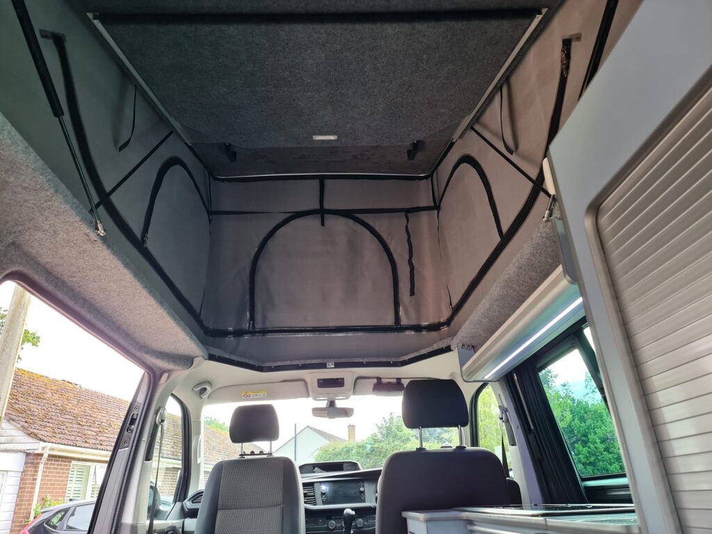 Plywood floor panels being fitted in a stripped VW Transporter during conversion