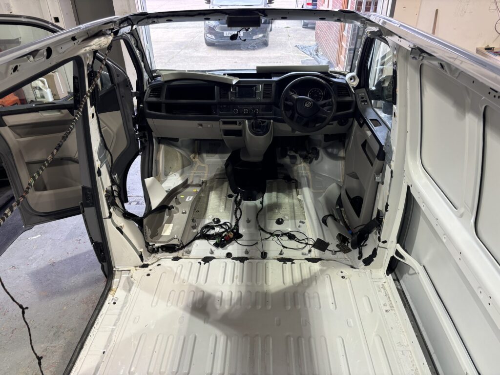 VW Transporter interior stripped to bare metal at the start of a campervan conversion